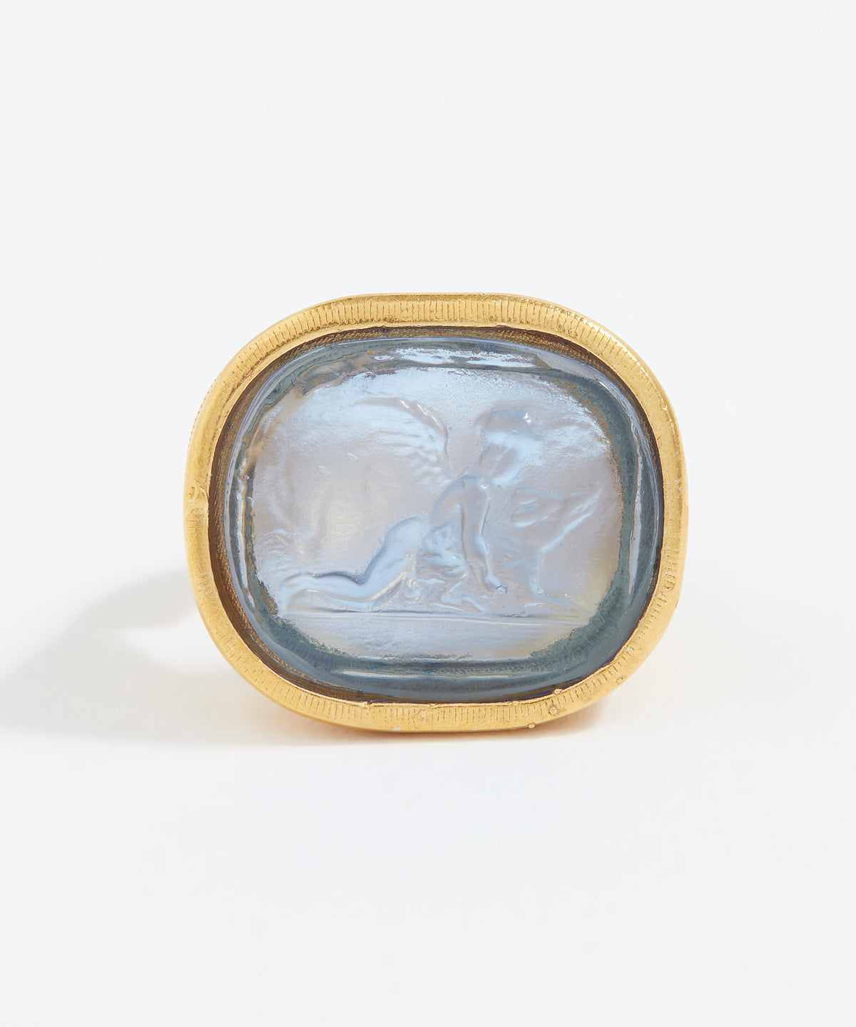 Gold ring with a stone featuring an engraved design on a white background