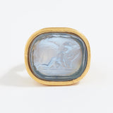 Gold ring with a stone featuring an engraved design on a white background