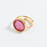 Gold ring with a pink stone on a white background