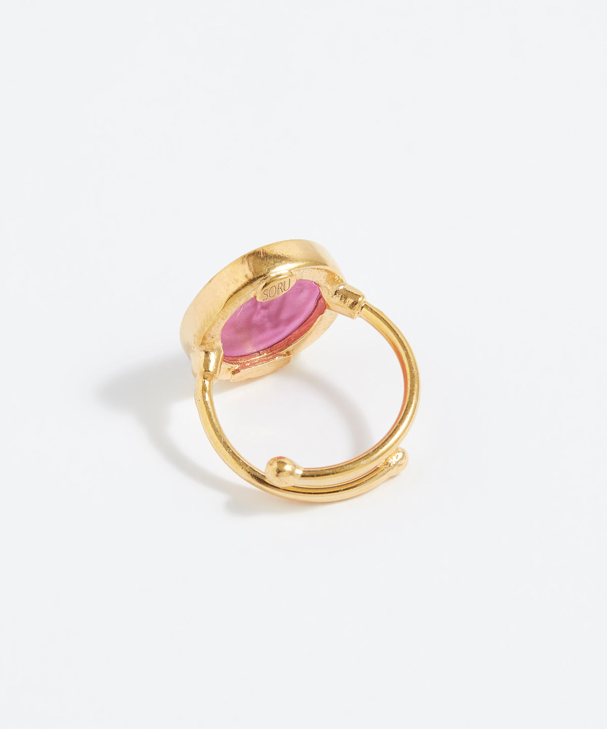 Gold ring with a pink stone on a white background