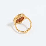 Gold ring with a circular design on a white background