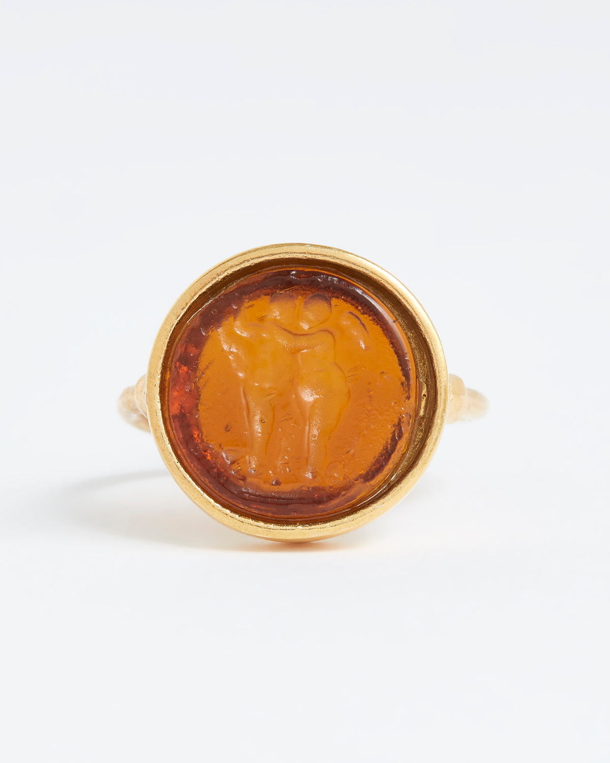 Gold ring with a circular topaz stone featuring a engraved design on a white background