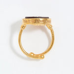 Gold ring with engraved text "This Too Shall Pass" on a white background