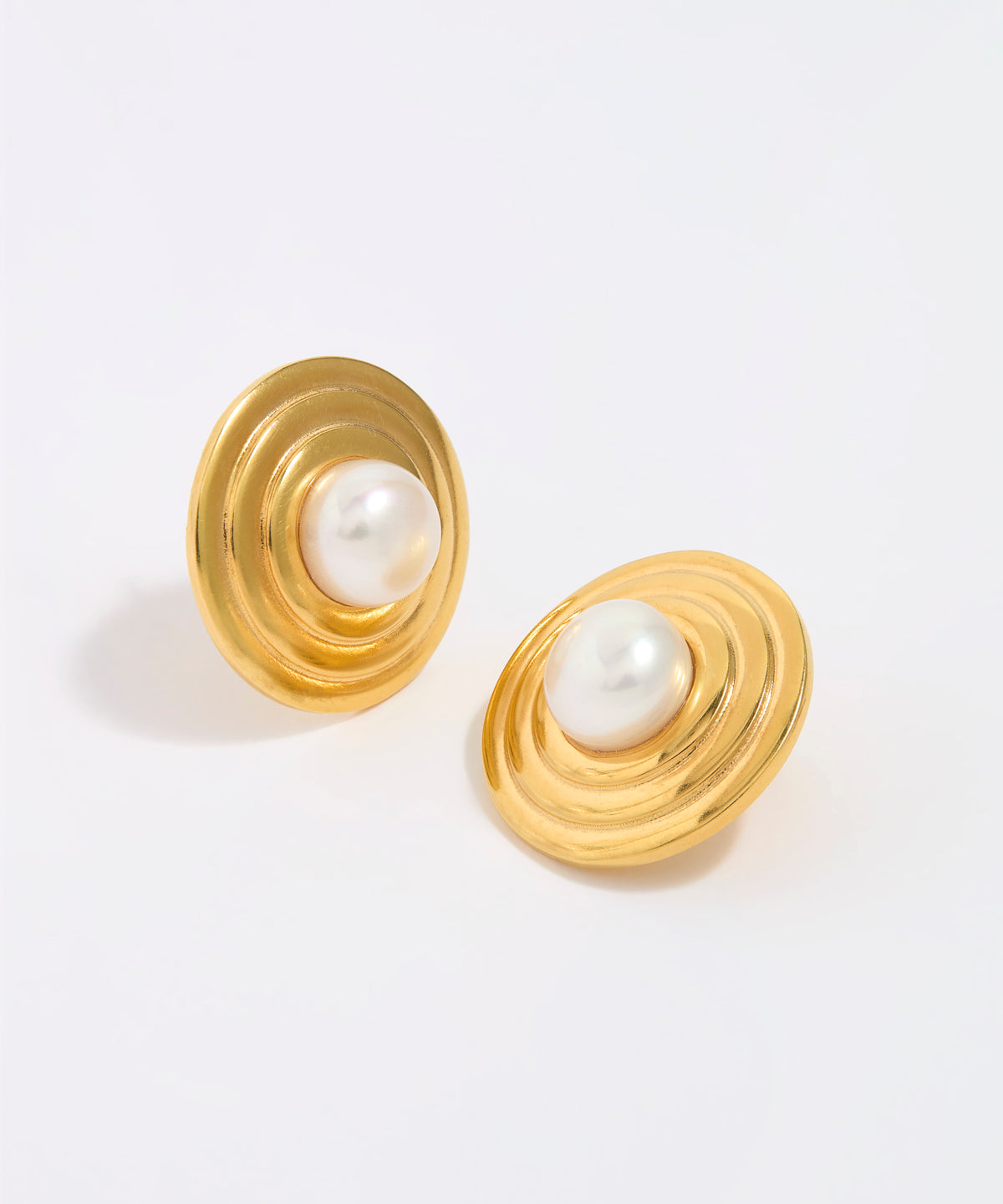 Gold earrings with pearl centers on a white background
