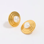 Gold earrings with pearl centers on a white background
