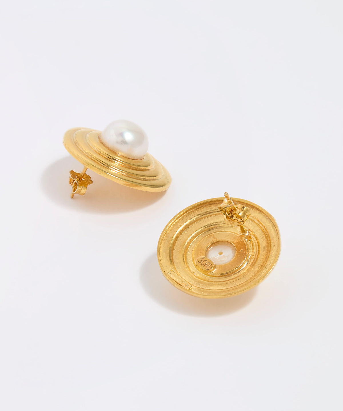 Gold earrings with pearl centers on a white background, showing back of earring
