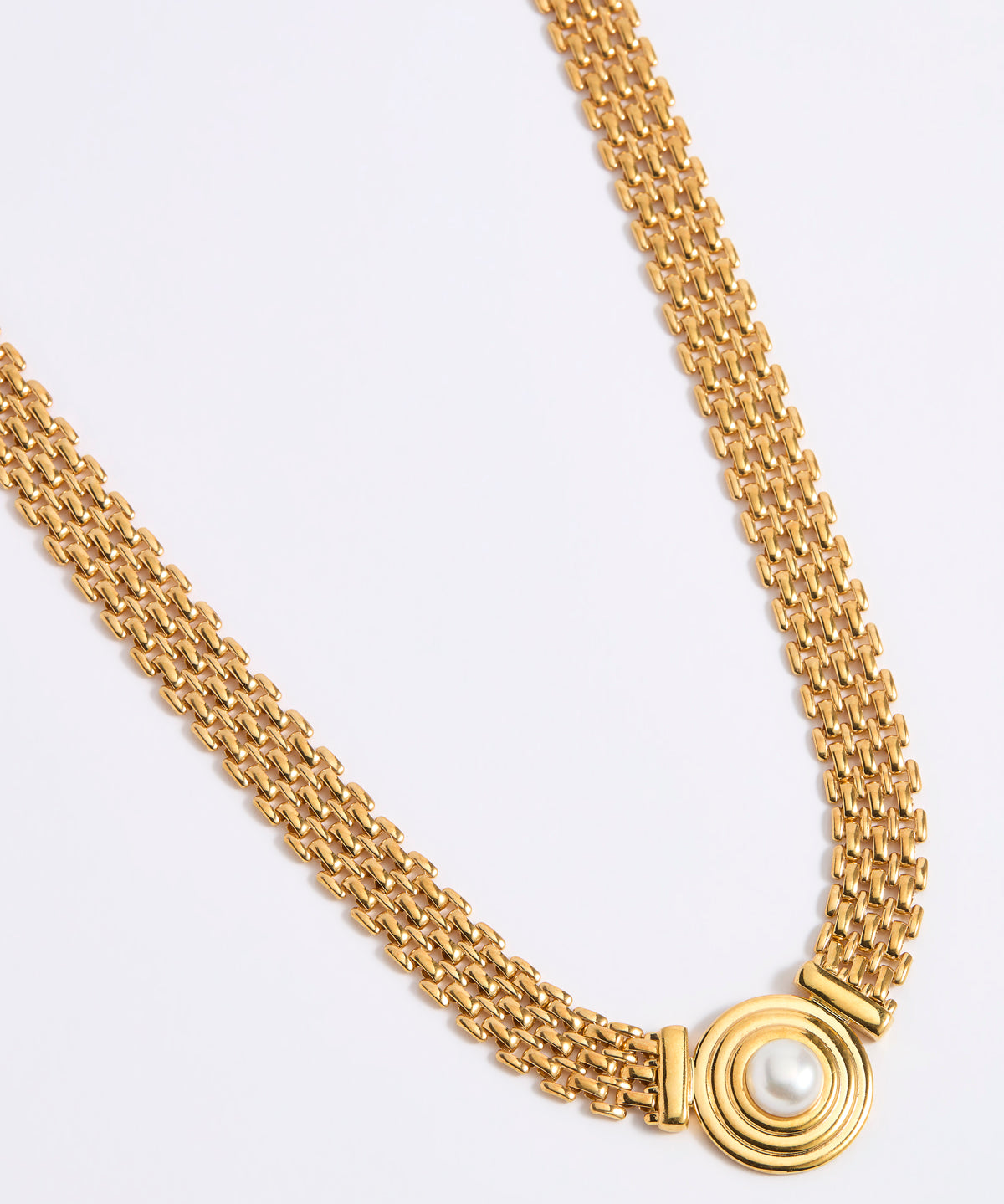 Gold chain necklace on a light gray background