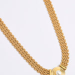 Gold chain necklace on a light gray background