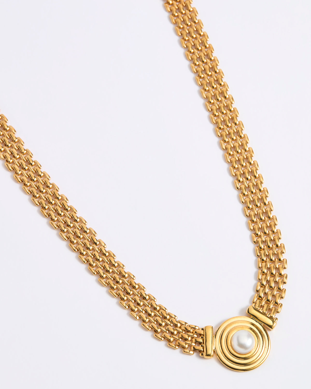 Gold chain necklace on a light gray background
