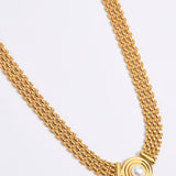 Gold chain necklace on a light gray background