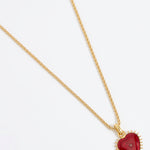 Product shot of Soru Jewellery red heart charm hung from a rope charm chain on white background