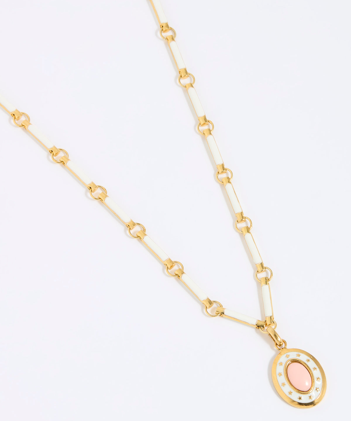 Gold coloured and white enamel necklace with a pink pendant on a white background