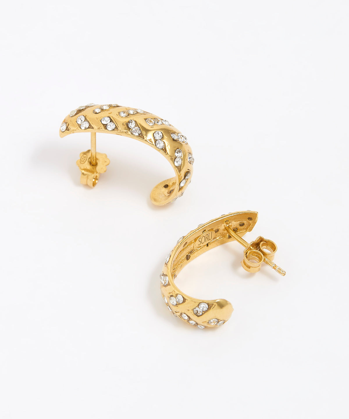 Gold hoop earrings with clear gemstones on a white background