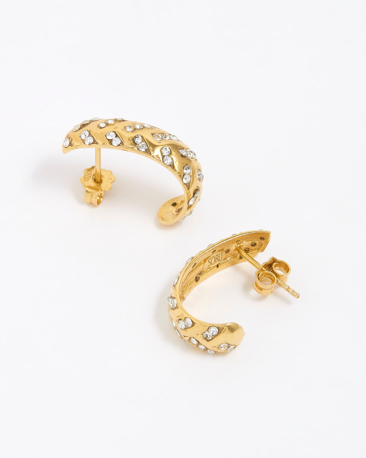 Gold hoop earrings with clear gemstones on a white background