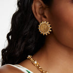 model shot waering the Soru Jewellery crystal embellished coin stud earrings and a gold and crystal necklace