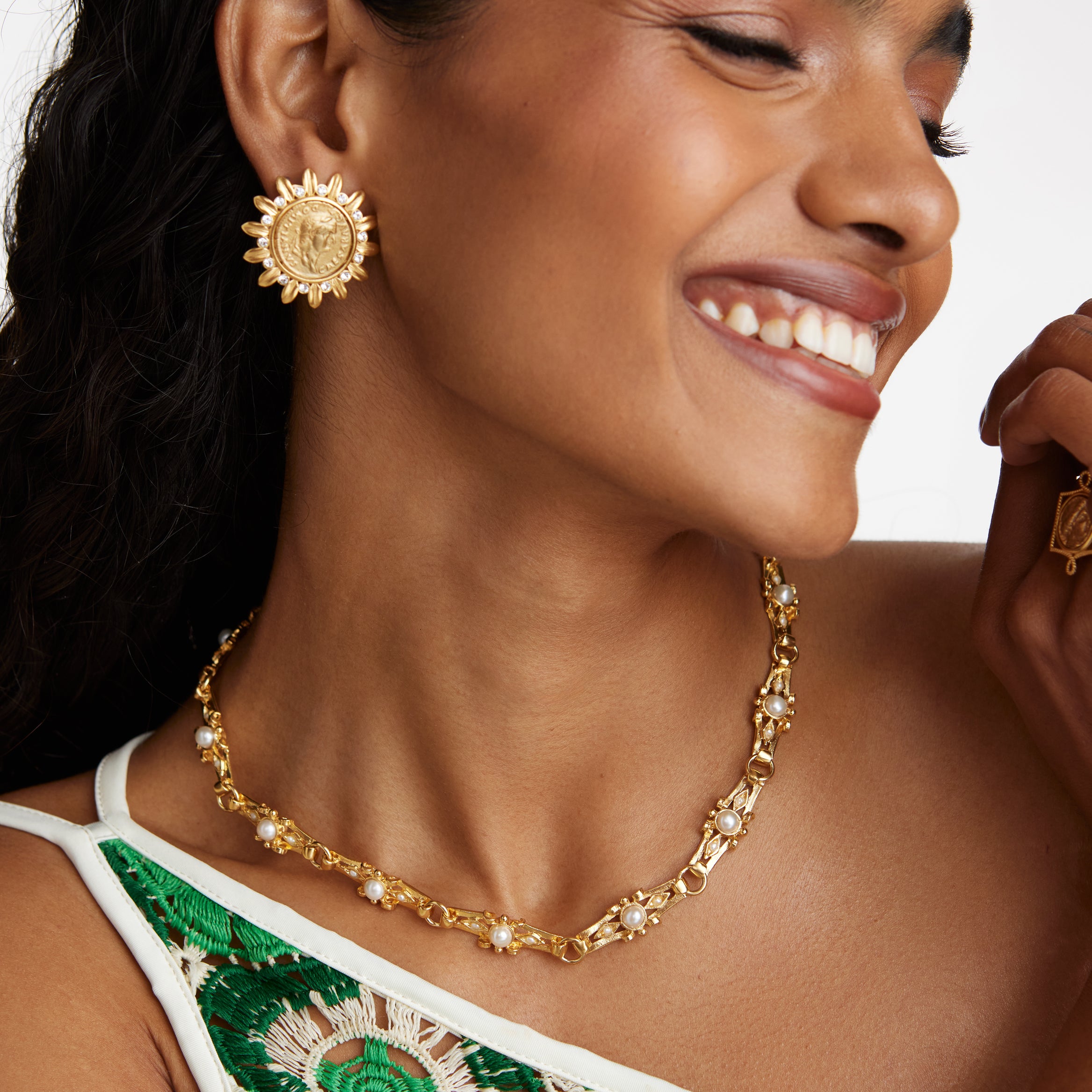 model shot wearing the soru jewellery gold link necklace with pearl detail, gold coin earrings and a chunky gold bracelet while smiling