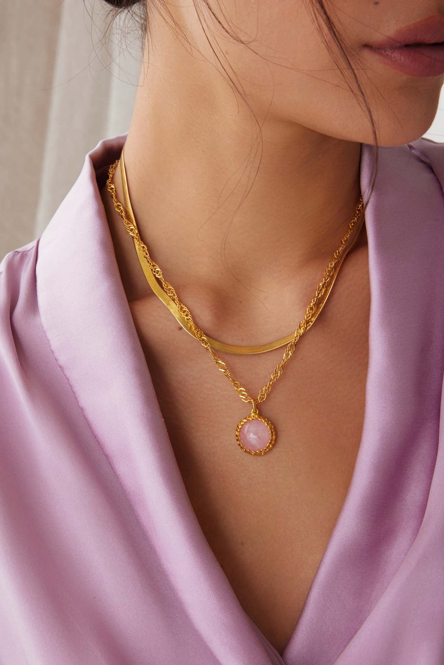 model shot of the PINK ROSE QUARTZ pendant necklace on a gold twisted chain