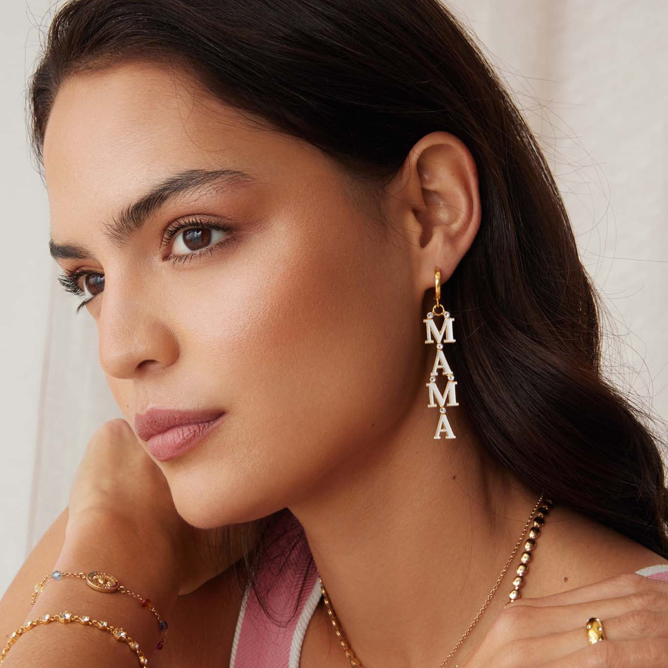 image of mama gold and white enamel earrings being worn
