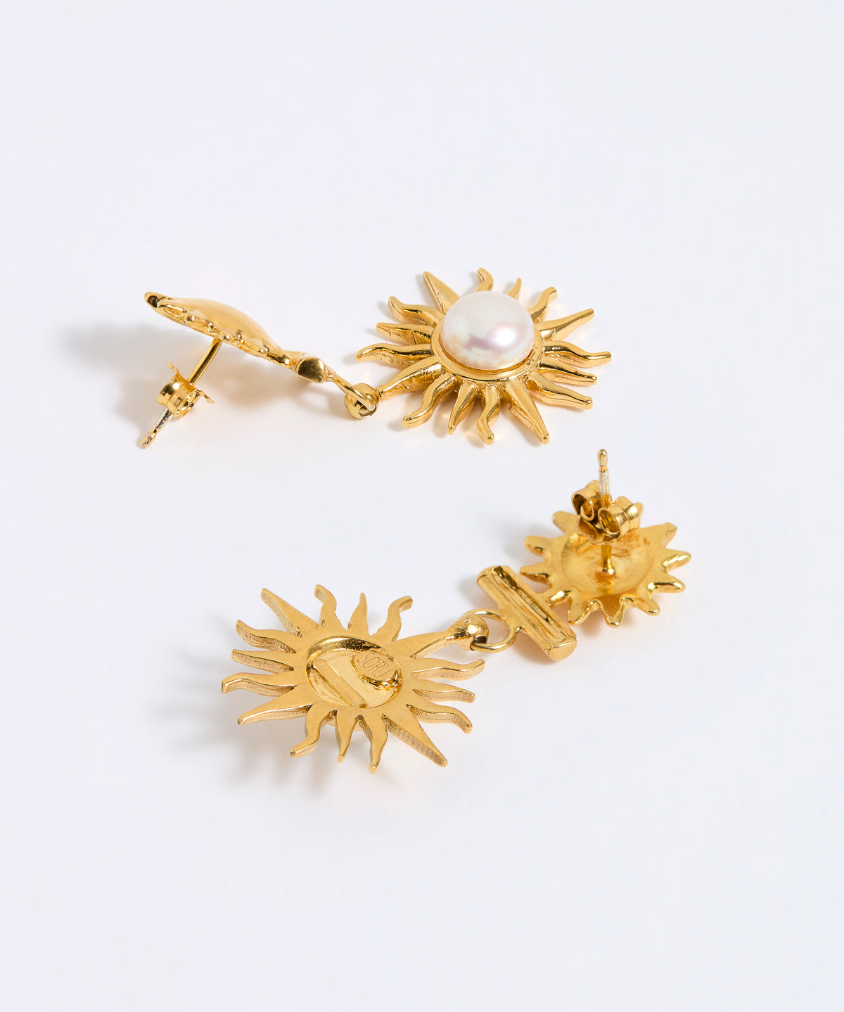 Gold sun-shaped earrings with a central pearl on a white background