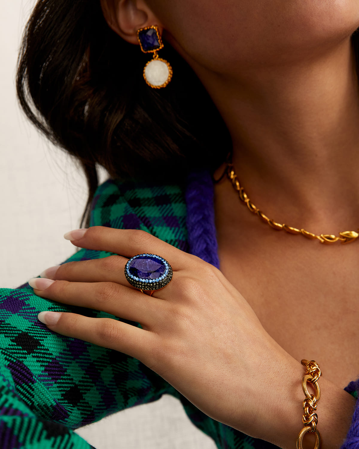 Image shows blue ring, gold necklace and gold bracelet