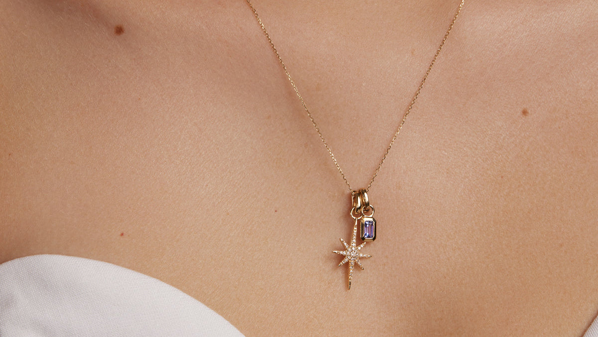 gold and diamond shining star charm, model shot of charm on necklace 