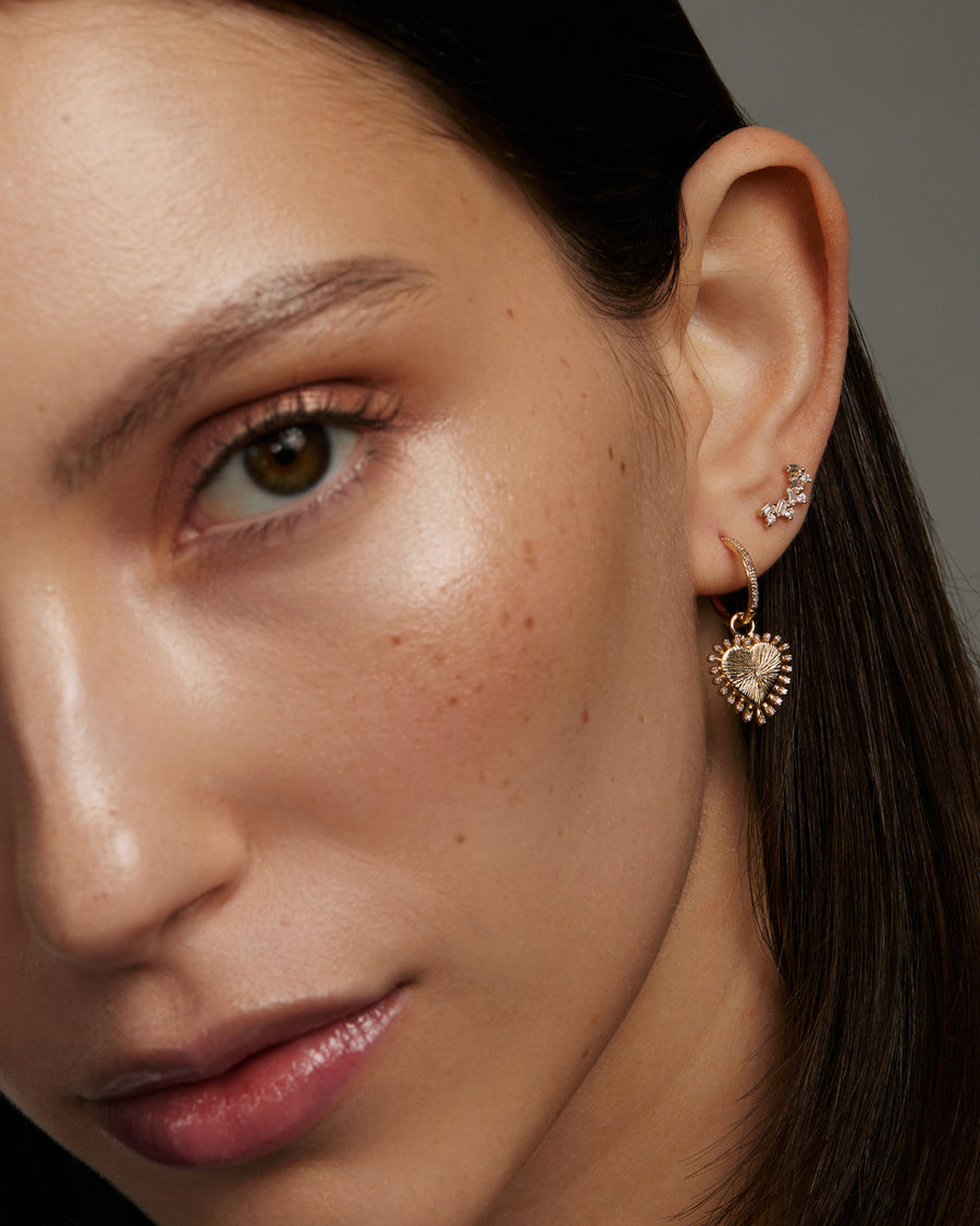model shot of gold and diamond heart charm on earring