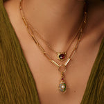 model shot of scarab beetle charm encrusted with red, bue and green crystals and one pearl on the back