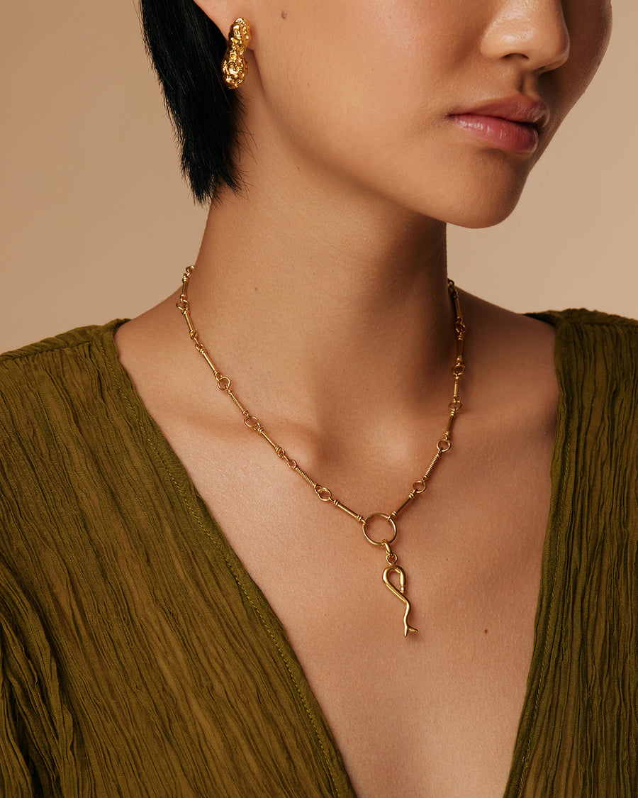 model shot of chunky, gold bar stud earrings with a bumpy, organic finish