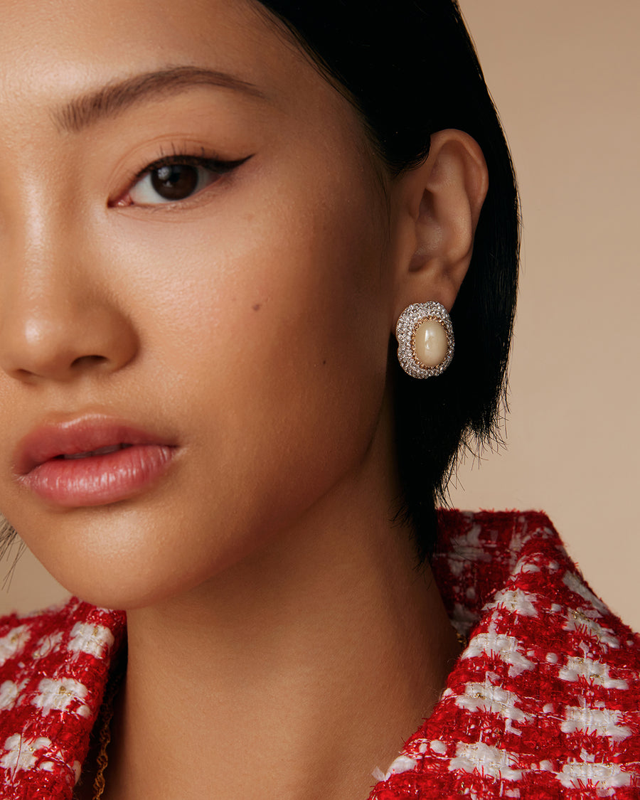 model shot of large pearl stud earrings surrounded by crystals
