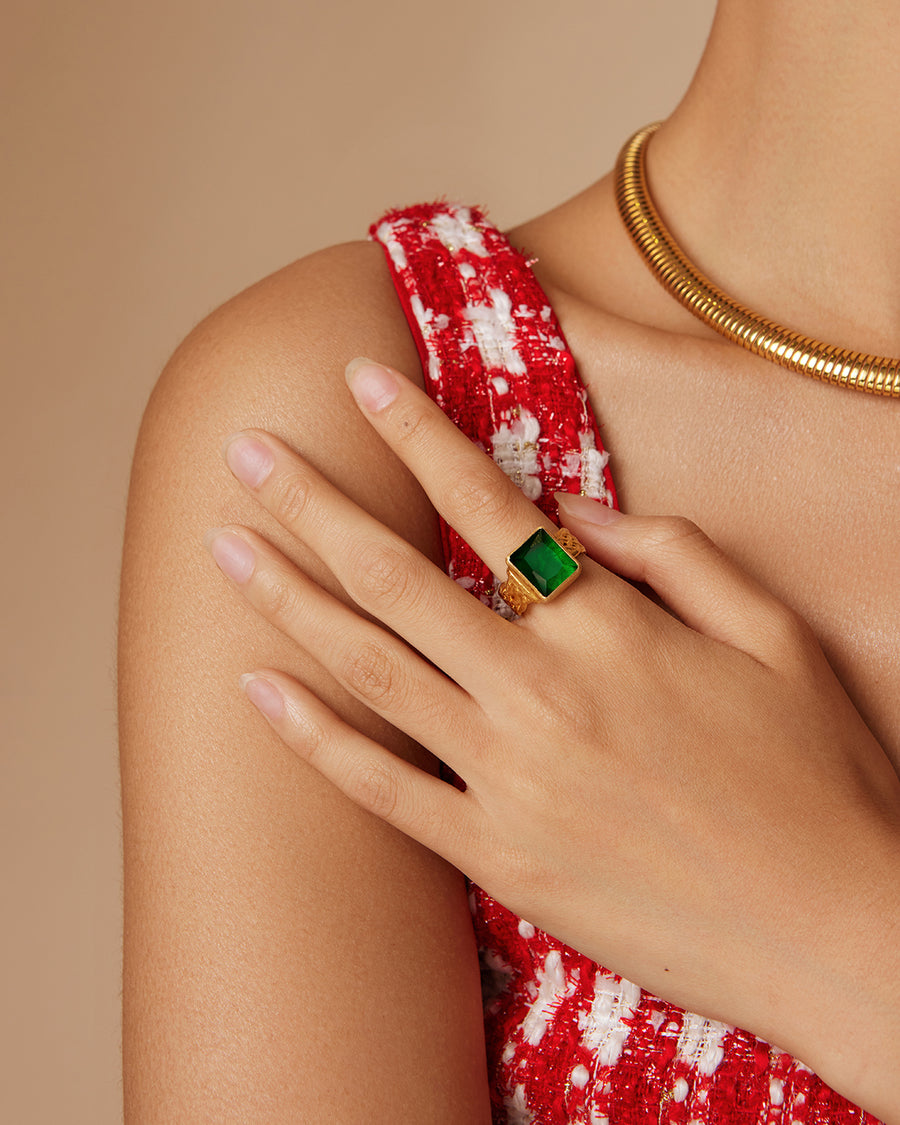 on model shot of yellow gold plated ring with large green rectangular crystal