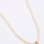 Pearl necklace with a gold clasp on a white background