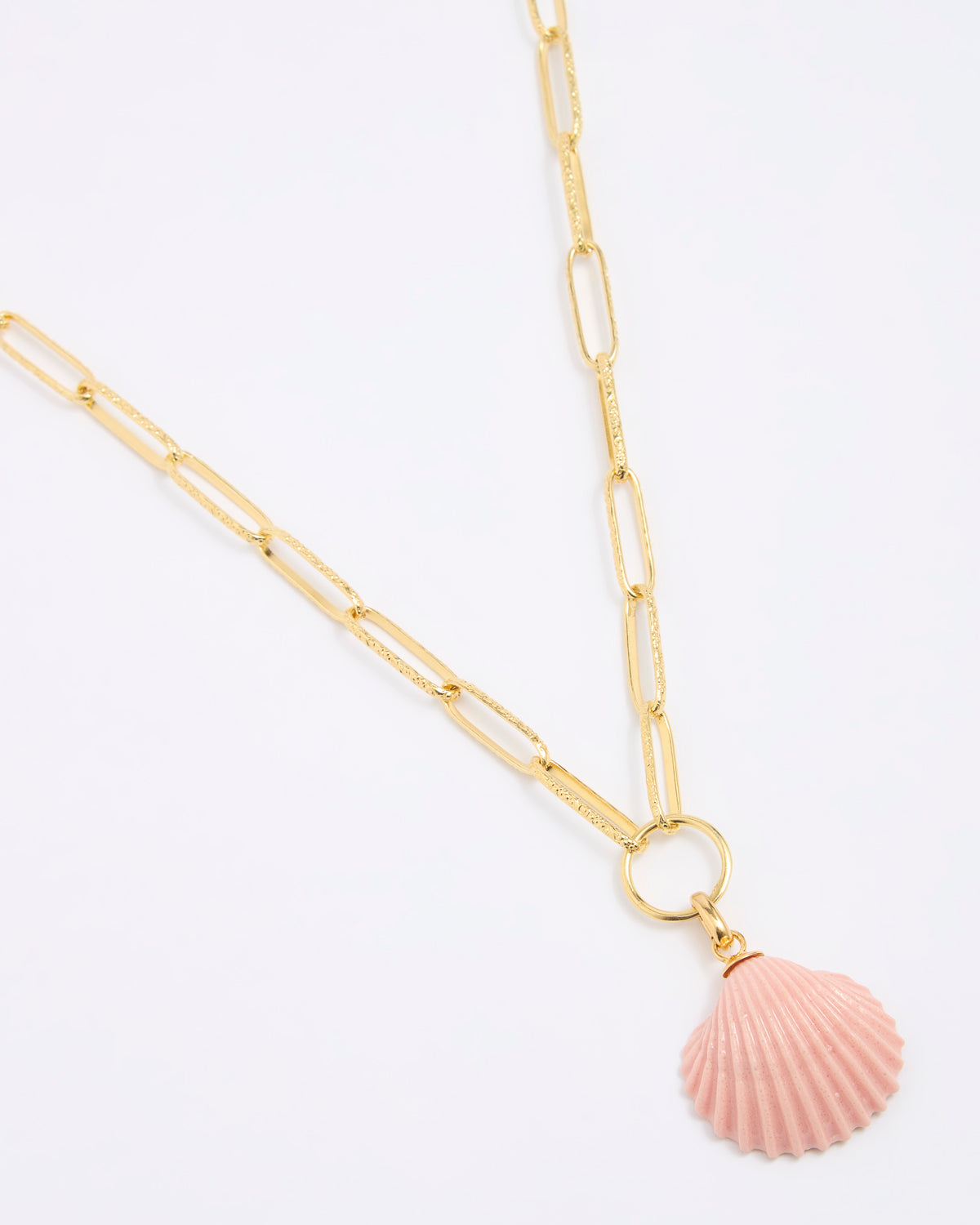 Gold coloured chain necklace with a pink shell pendant on a white background