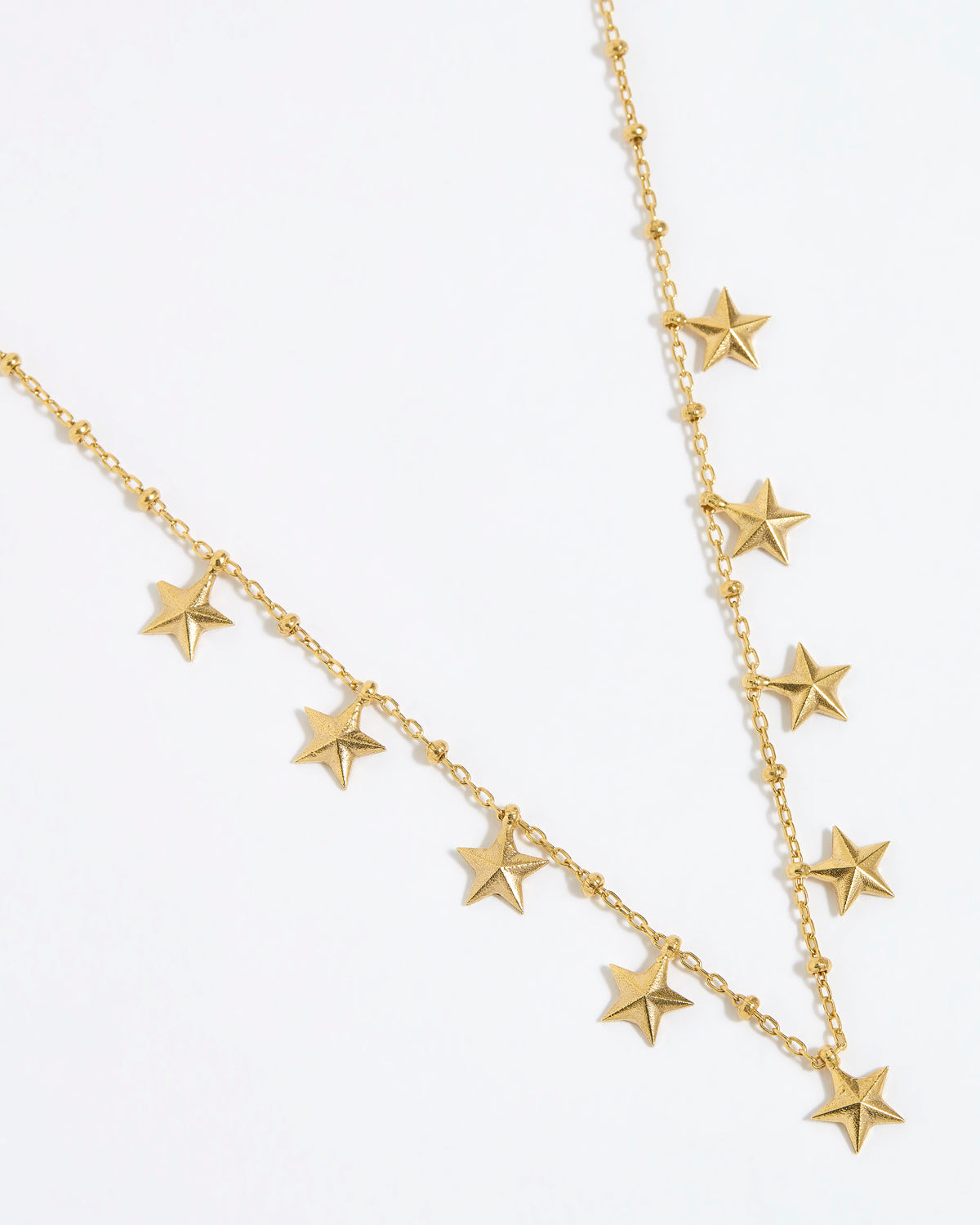 gold chain necklace with nine small dangling stars on white background