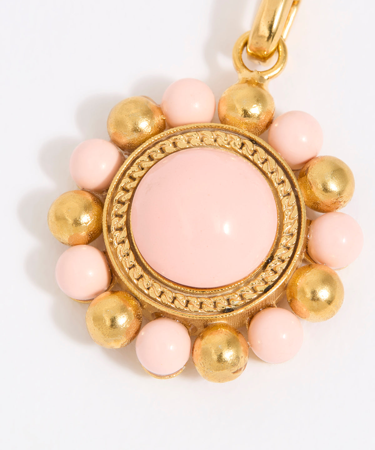 Decorative charm with pink and gold beads on a white background
