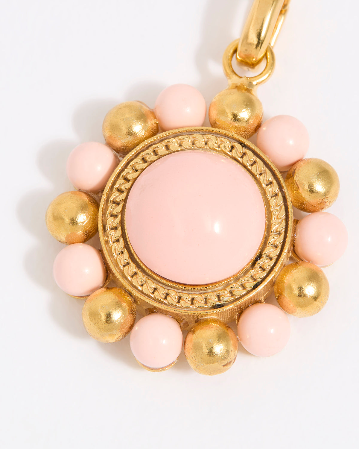 Decorative charm with pink and gold beads on a white background