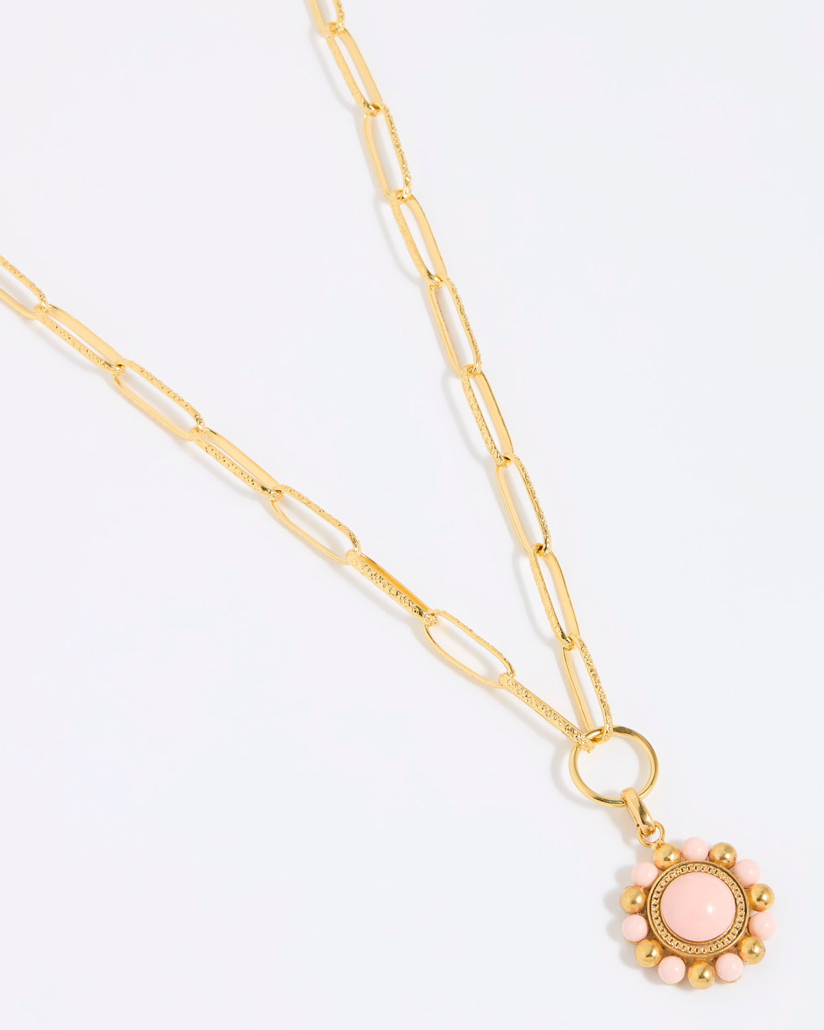 Gold coloured chain necklace with a pink floral pendant on a white background