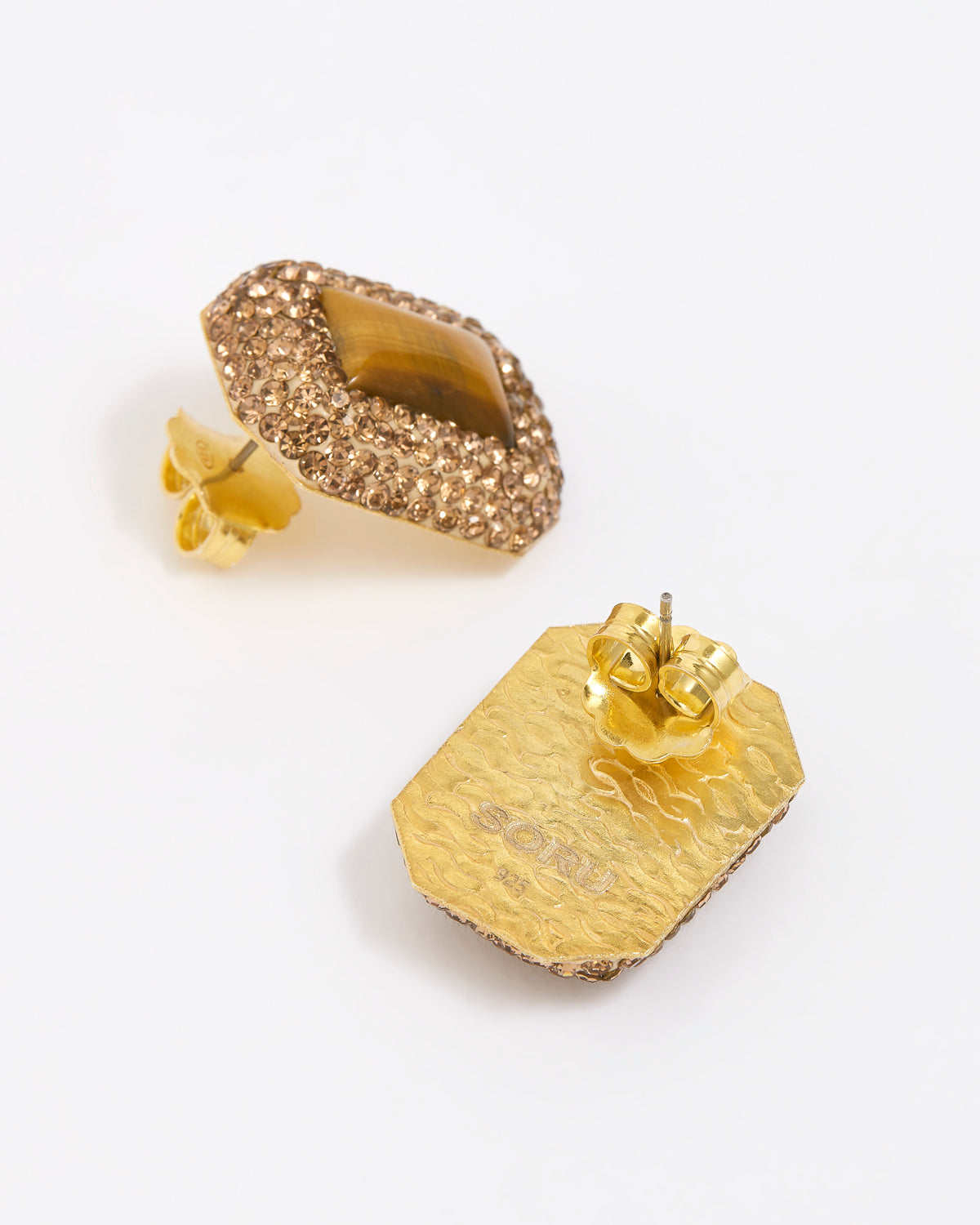 Pair of square stud earrings with brown crystals around a square tigers eye gemstone, on white background