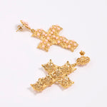 Gold cross-shaped earrings on a white background