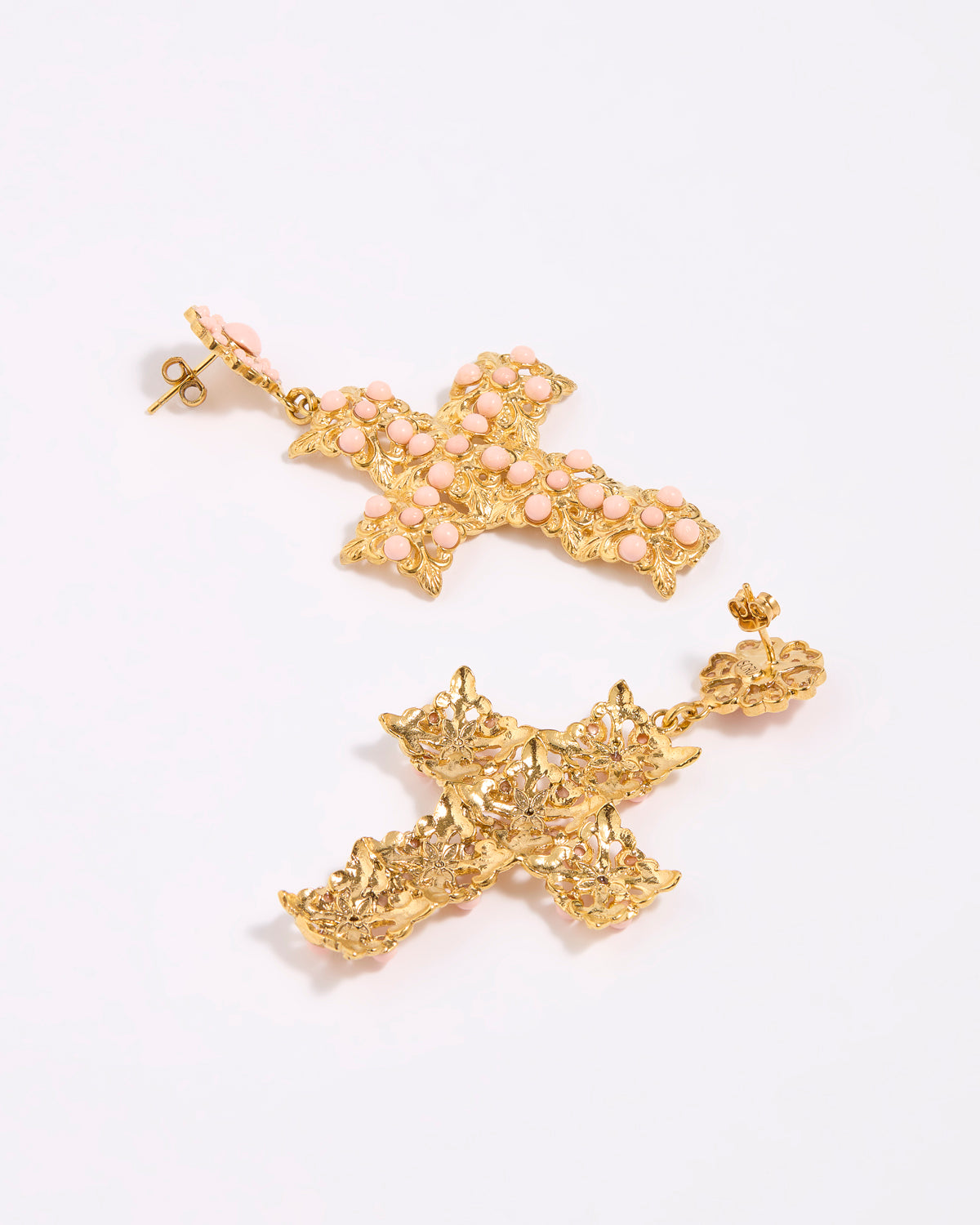 Gold cross-shaped earrings on a white background