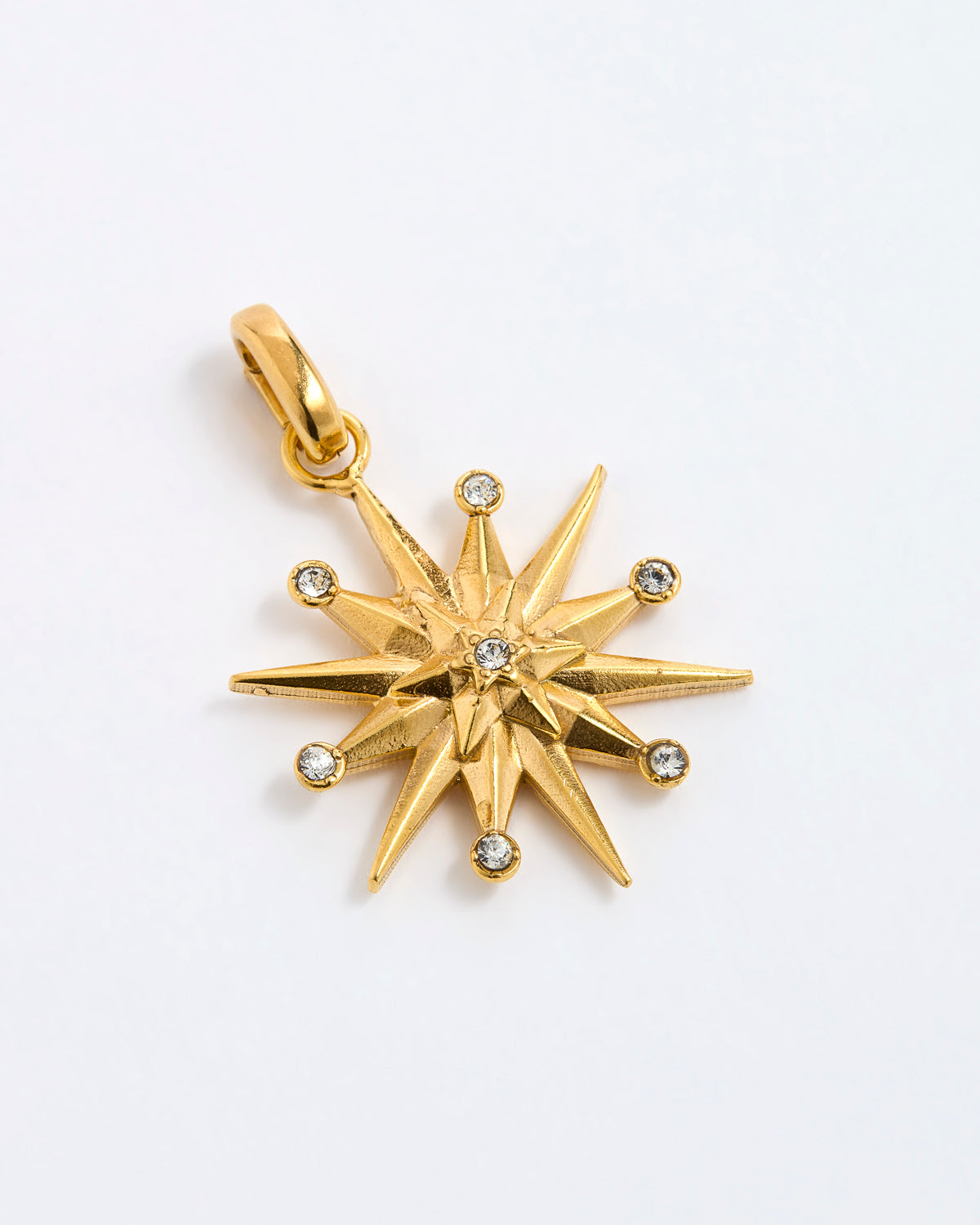 12-pointed star charm pendant featuring a central clear gemstone and six surrounding small round-cut stones, displayed on a white background.