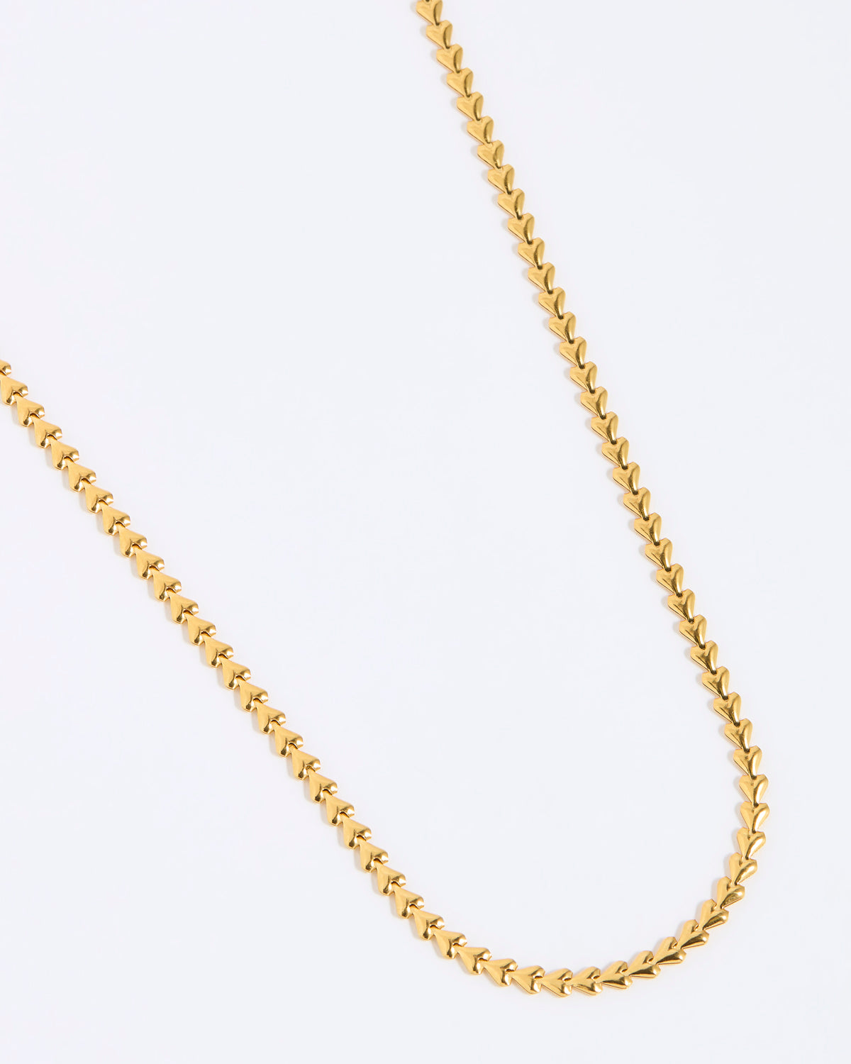 Gold chain of small hearts shown on white background