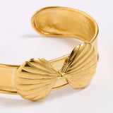 Gold coloured bracelet with shell design on a white background