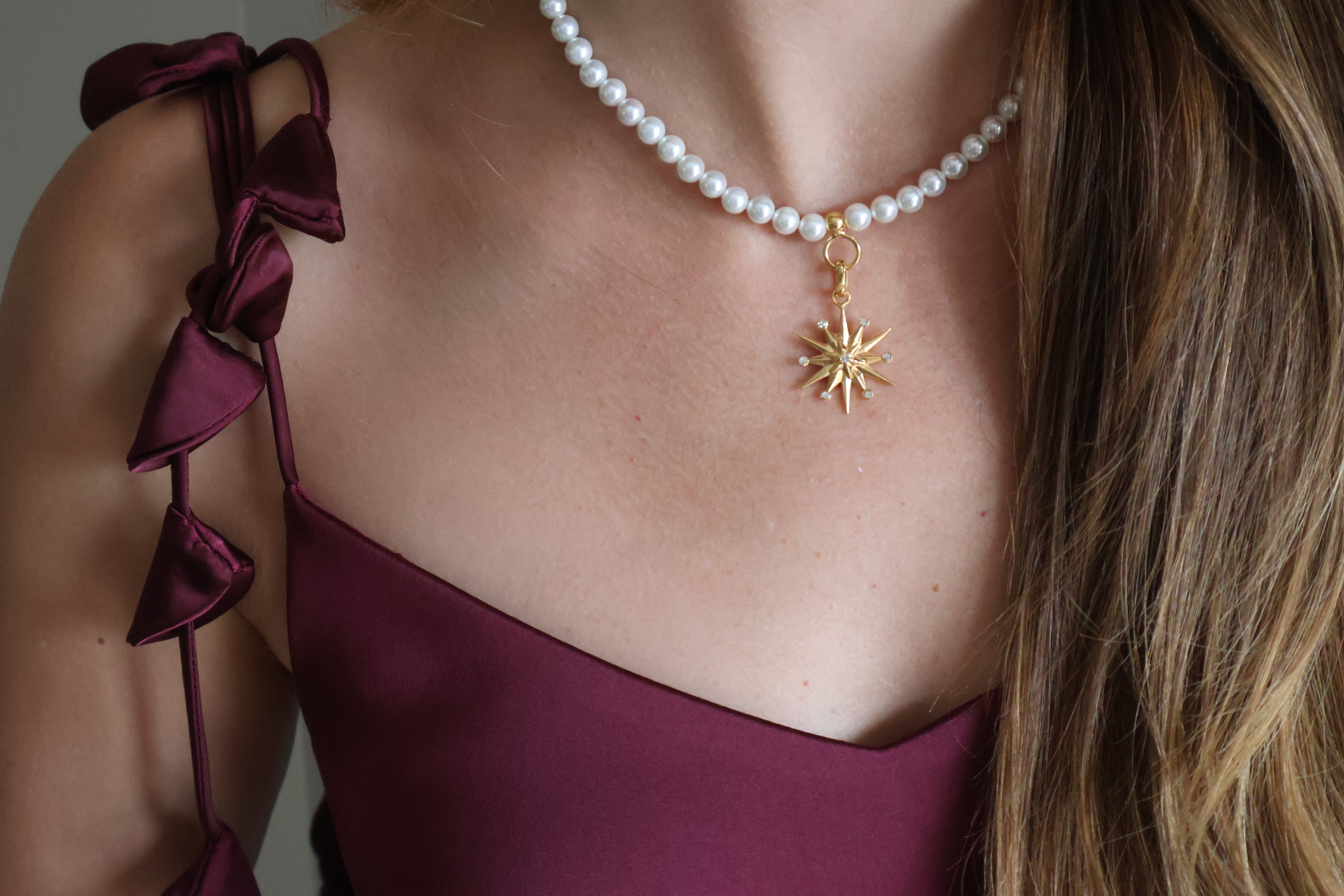 close up of pearl necklace and star charm attached. 