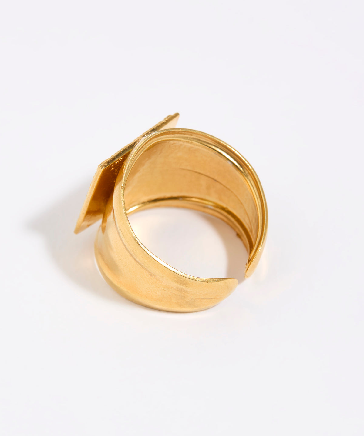 Gold ring with a unique design on a white background