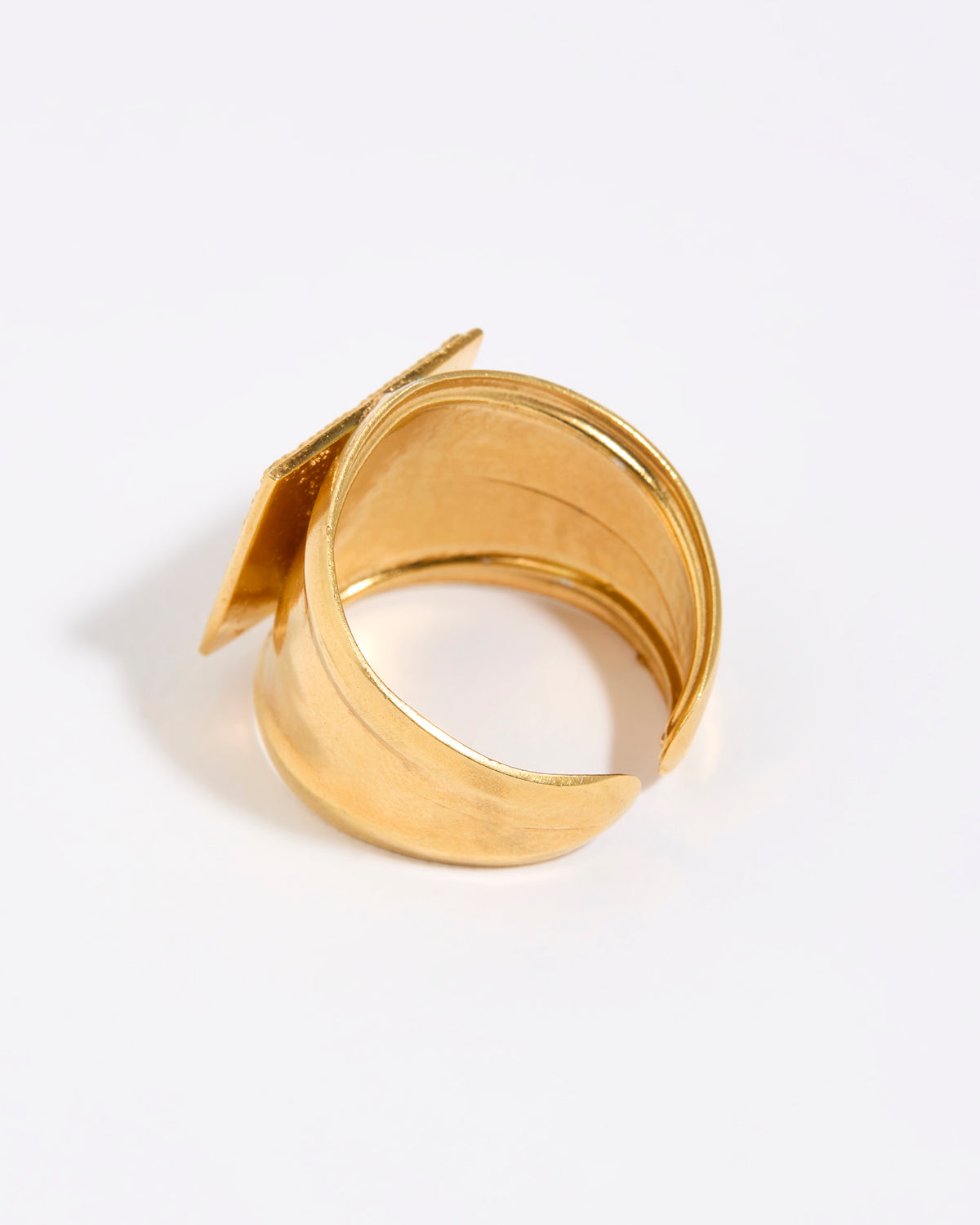 Gold ring with a unique design on a white background