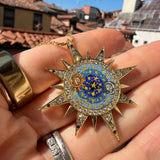 celestial design micro mosiac pendant being held in a hand up close 