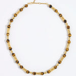 Beaded necklace with gold and tigers eye beads on white background
