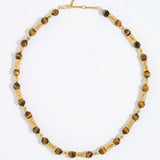 Beaded necklace with gold and tigers eye beads on white background