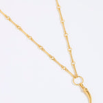 Gold necklace with cornicello charm pendant on a white background