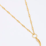 Gold necklace with cornicello charm pendant on a white background